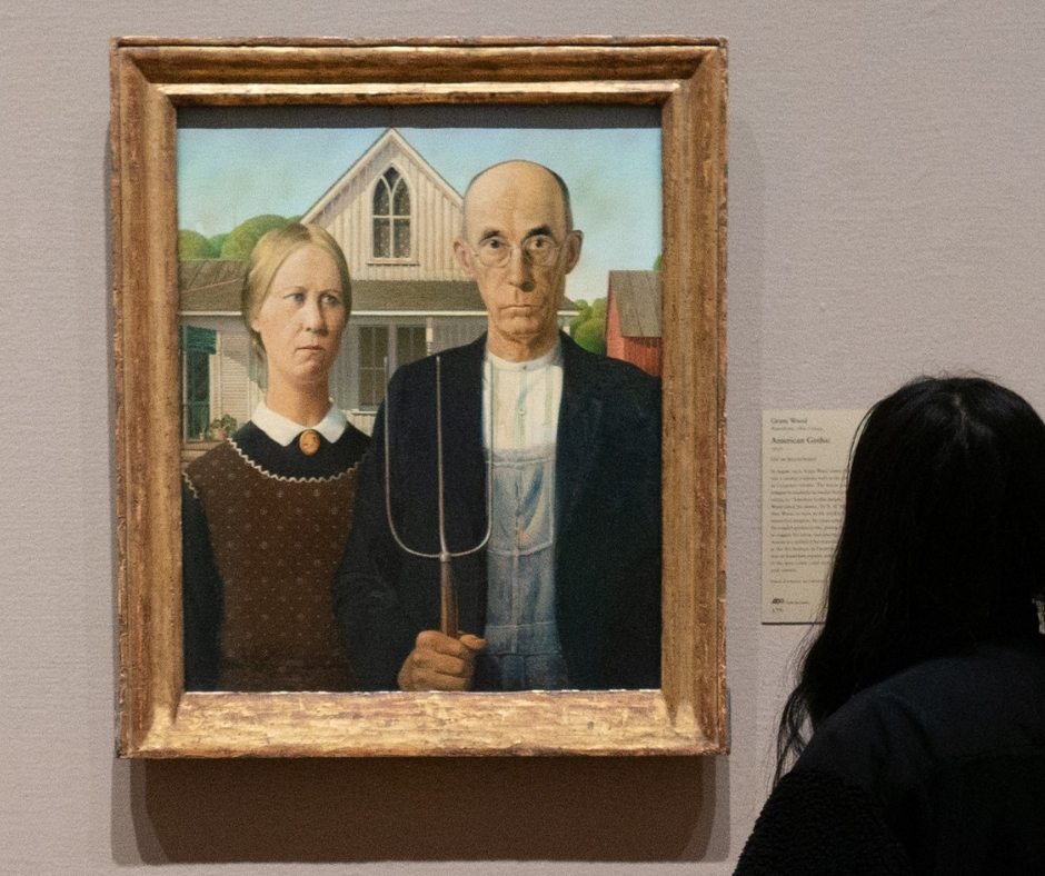 Woman Looks At American Gothic Painting