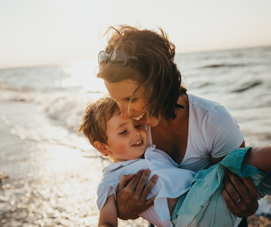 Woman Holding Son At Beach