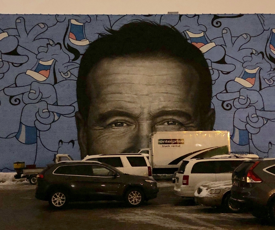 Cars In Front of Wall Painted With Robin Williams' Face & Genie From Aladdin