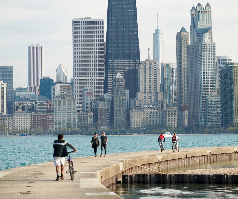 City Skyline With Bikers On River